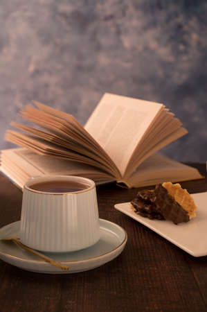 A great photo of morning relaxation is done in warm colors. A cup of tea and a book is the best start to the day. A romantic mood will improve your well-being and health. Enjoy the sunrise.の写真素材