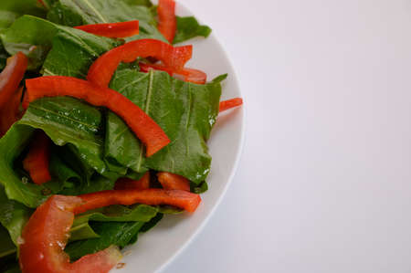 Healthy food in the form of vegetable salad. Fresh vegetables are arranged on a white plate. On the...