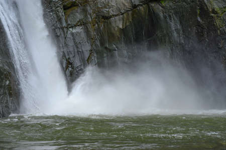 The photo shows a huge waterfall. Below is a perfectly clear water mirror. The area is full of tropical greenery. The waterfall is photographed in the Dominican Republic.の写真素材