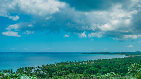 Photo of a sandy beach in the foreground from the Dominican Republic. The picture clearly shows the magnificent sand from the Atlantic Ocean and the bright blue sky, forming a horizon line.の写真素材
