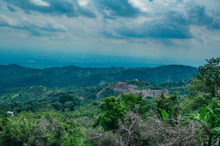 The photo shows mountains with green rainforests. Fog or steam is visible between the mountains. The picture was taken at an altitude of 2000 meters in the Dominican Republic.の写真素材
