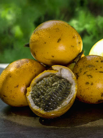 The photo shows an exotic fruit native to the tropics. The tropical fruit is called granadilla or sweet passionfruit. Granadilla is orange in color with many seeds inside.の写真素材