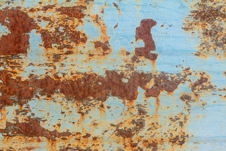 Rust.Old blue painted wall with rust spots.Textured rusty metal background. Rust stains through the...
