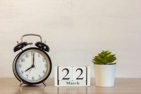 March 22 on a wooden calendar next to the alarm clock. Calendar date, holiday event, or birthday.の写真素材