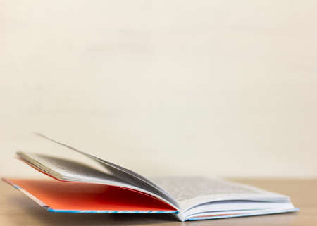 An open hardcover book is lying on the table.の写真素材