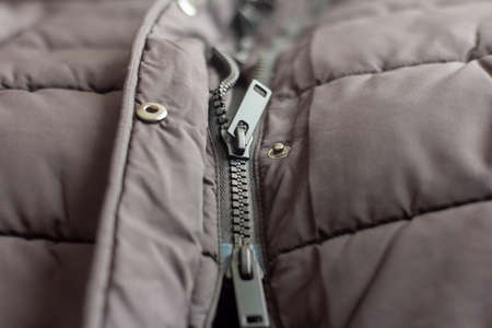 Semi-buttoned plastic tractor lock on a black down jacket.の写真素材