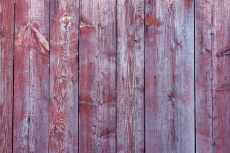 Old wooden background with peeling red paintの写真素材
