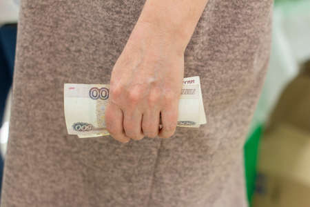 A woman holds paper money in her hands