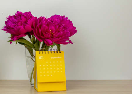 Calendar for September 2021 and peonies on the table. Desktop calendar for planning, scheduling, assigning, organizing, and managing each date.の写真素材
