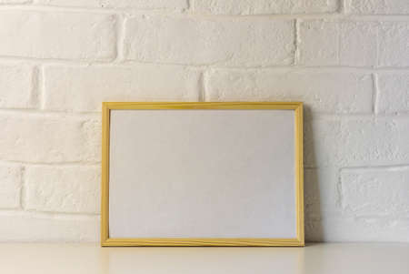 A mock-up of a wooden frame for a photo or a picture on a table with a copy of the...