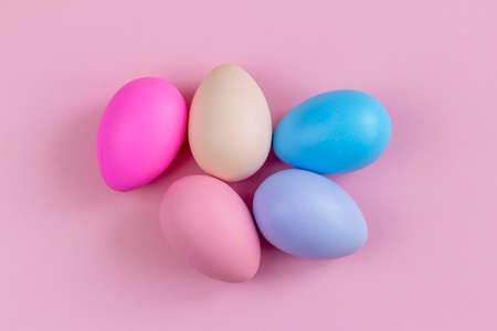 Colorful Easter eggs on a pink background, top view