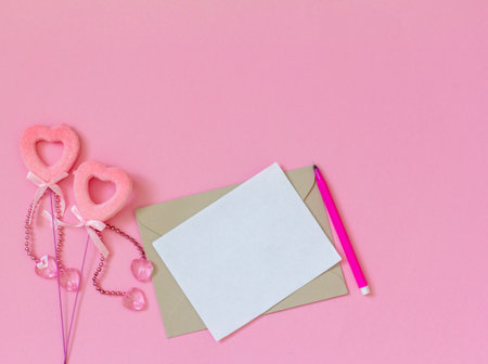 a mock-up of an empty greeting card and two hearts on a pink background