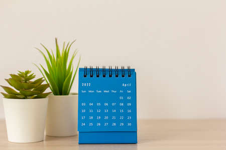 Desktop blue calendar for April 2022 on the tableの写真素材