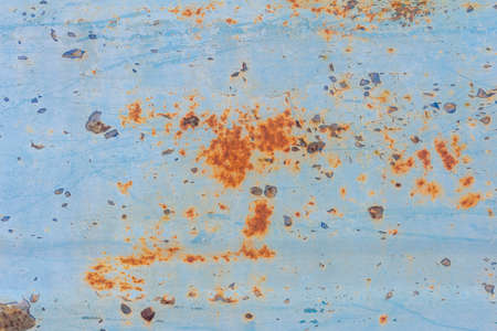 A rusty blue metal wall with fallen paint, a rusty background