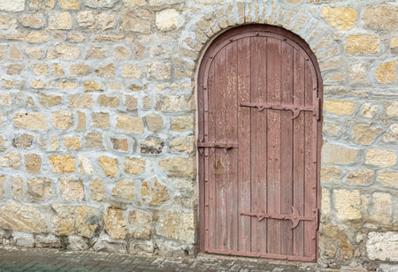 An old wooden door in a stone wall.The entrance to the ancient towerの写真素材