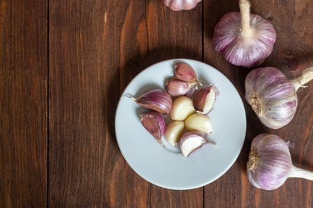 Garlic.Cloves and whole garlic heads on an old wooden tableの写真素材