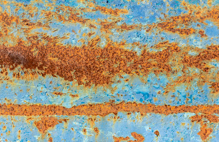 A rusty blue metal wall with fallen paint, a rusty background