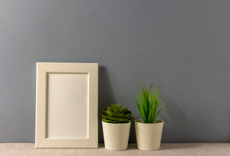 The layout of an empty photo frame on the table.Succulents in mini pots. A minimalistic workspace...