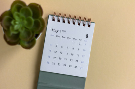 Hello, desk calendar for planning for May 2025 on a beige backgroundの写真素材