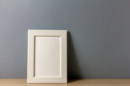The location of the empty photo frame on the table. A minimalist-style workspace. A place to copyの写真素材