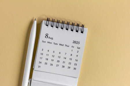Hello, August 2025. Desktop calendar for planning on a beige background with a copy of spaceの写真素材