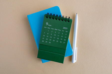 Hello, September 2025. Desktop calendar and notepad for writing on the desktopの写真素材