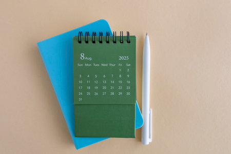 Hello, August 2025. Desktop calendar and notepad for writing on the desktopの写真素材