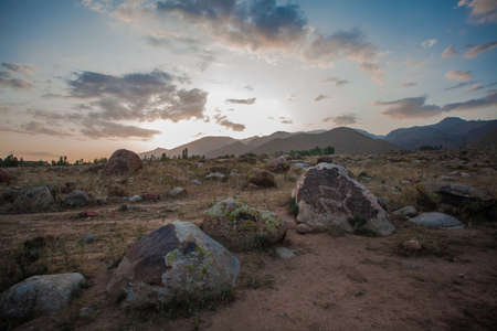 Petroglyphs on stones. In are far mountains are visibleの写真素材