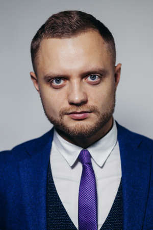 Portrait of serious fashionable handsome man in blue suit looking at cameraの写真素材