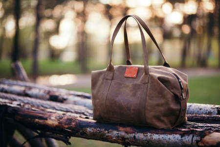 Travel backpack on the wooden bench in the forest. Summer active hiking and trekking tools.の写真素材