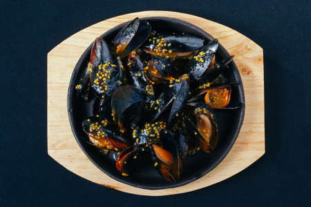 Fresh tasty Boiled mussels with herbs on wooden board.の写真素材
