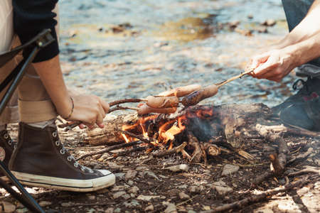 Sausages barbecue on the stick above the fire in the nature.の写真素材