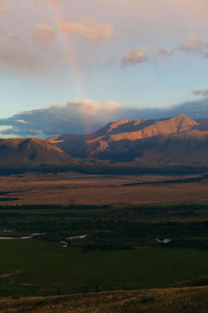 Rainbow in the mountain valley after rain. Beautiful landscape