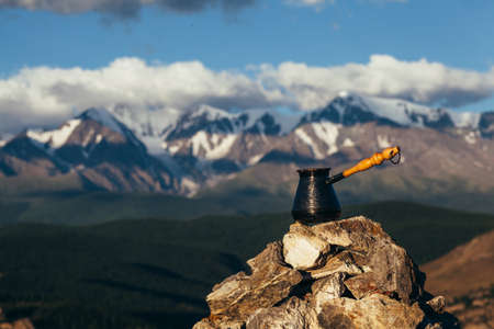 Drinking coffee with stunning mountain view. Beautiful Himalayas landscape with coffee cups and cezve. Drinking coffee outside on a background of snowy landscape.の写真素材