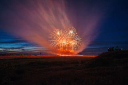 Fireworks over the city. Multi-colored fireworks against the background of the sunset sky