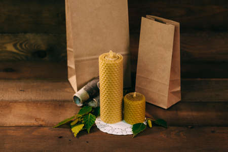 Christmas candles with gift boxes. Birch leaves and wooden background.の写真素材