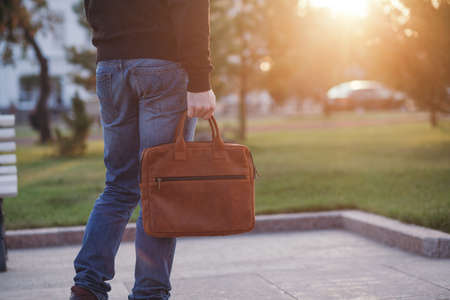 Handsome man with a leather bag in the city.の写真素材
