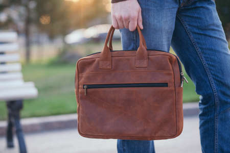 Handsome man with a leather bag in the city.の写真素材