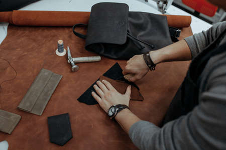 Close-up. Male hand master cut with a knife to skin products. Small business.の写真素材