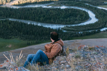 Man sitting on top of mountain. Riverの写真素材