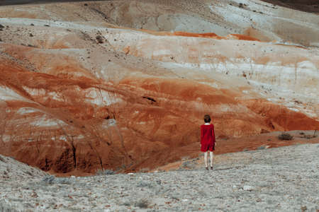 Woman stands in the beauty of red valley. She wears a beautiful red dress. Romanticの写真素材