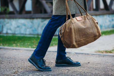 Busy man walking on street with bagの写真素材