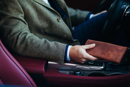 close up of the businessman in the car with a purseの写真素材