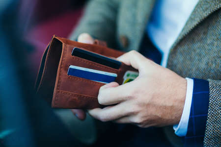 purse with money in the hands of a man driving a carの写真素材