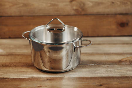 Stainless saucepan on wooden tableの写真素材