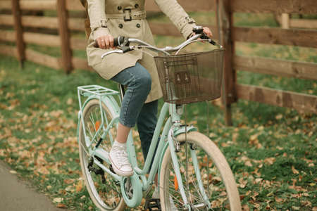 Girl in jeans and coat ridding a bicycleの写真素材