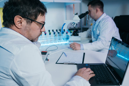 Portrait of a scientist working in the lab examines a test tube with liquid.の写真素材