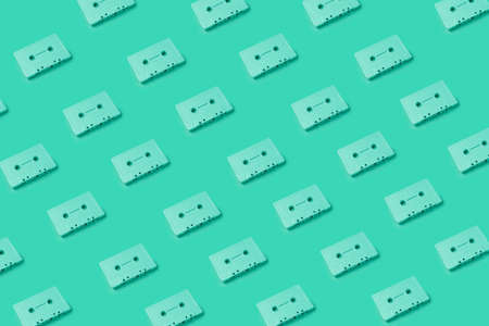 Green cassette tapes overload. Retro cassette tapes pattern on a green background. Minimalist art photography, creative art photography. Music tapes placed on a monochrome background pattern.の写真素材