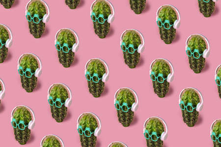 Trendy sunlight Summer pattern made with cactus pattern with headphones on pastel pink background. Minimal summer vacation concept.の写真素材
