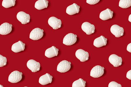 Minimal composition pattern background of white acorns on red background. Christmas, New Year...